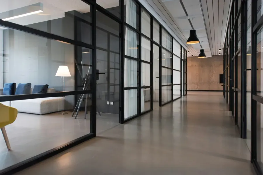 Clean modern office hallway with glass-walled meeting rooms