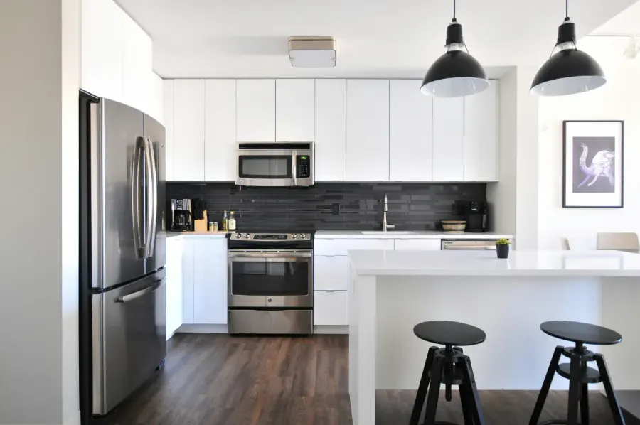 Clean white kitchen with stainless appliances and a breakfast bar